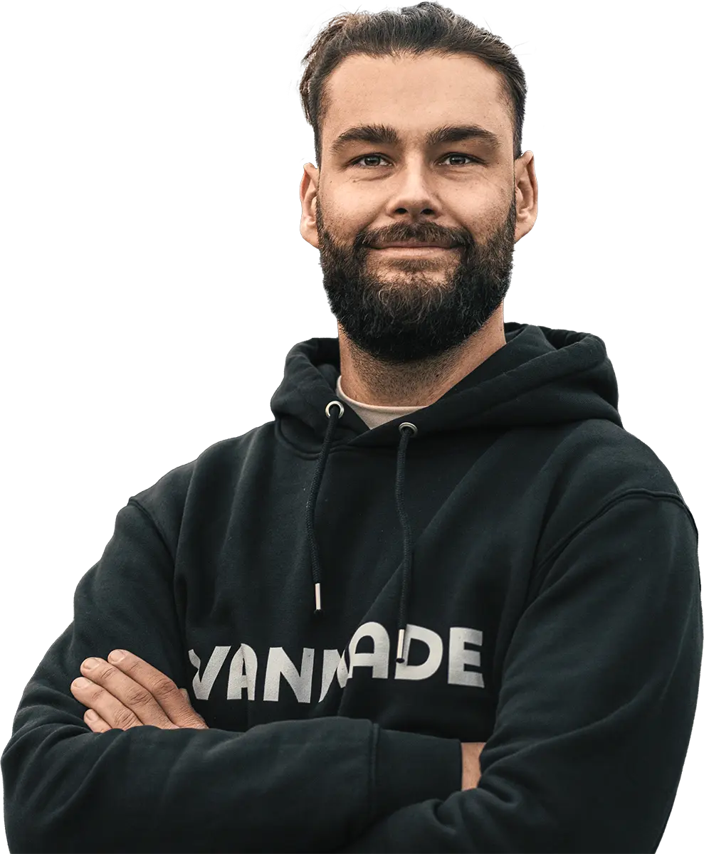 Stolzer Mann schaut steht mit verschraenkten Armen 