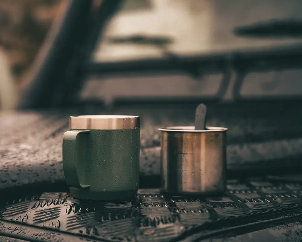 Zwei Kaffeebecher stehen auf der Motorhaube