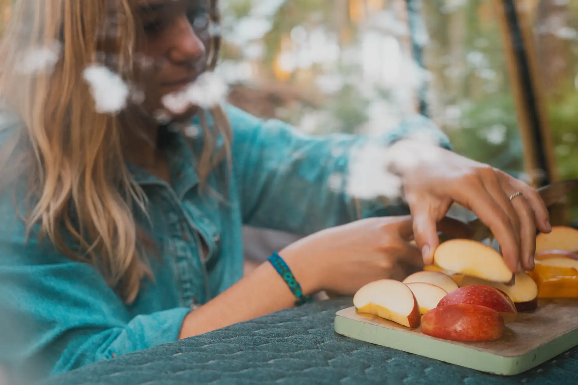 Lifestyle, junge Frau schneidet Obst auf Vanmade Matratze, dunkler Bezug