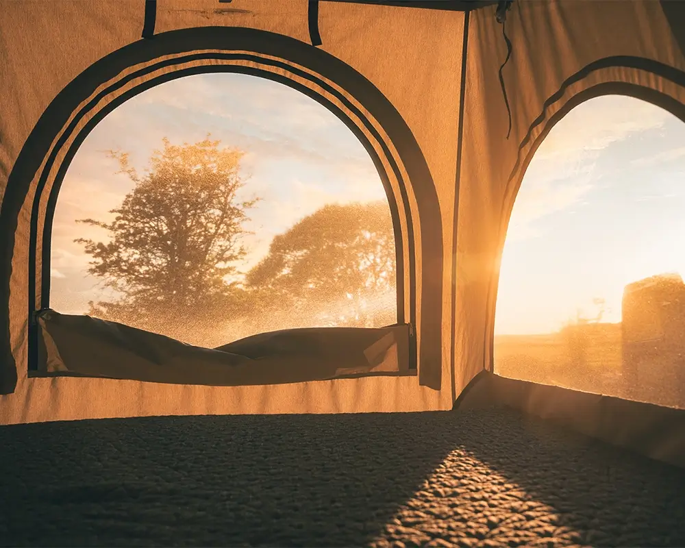 Die Abendsonne scheint durch das Fenster im Dachzelt auf die Vanmade Matratze